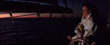 Movie still from “Dead Calm” (1989), directed by Phillip Noyce – A person sitting on a boat at night; Medium shot, Low angle