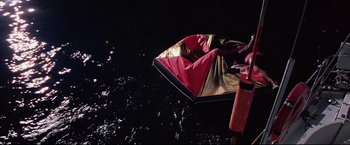 Movie still from “Dead Calm” (1989), directed by Phillip Noyce – A person is sitting on a boat in the water; Wide shot, Overhead angle