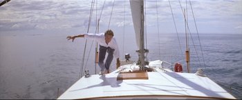 Movie still from “Dead Calm” (1989), directed by Phillip Noyce – A man riding a skate board on top of a sail boat; Wide shot, Low angle