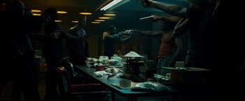 Movie still from “Dead Man Down” (2013), directed by Niels Arden Oplev – A group of people standing around a table; Wide shot, High angle