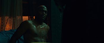 Movie still from “Dead Man Down” (2013), directed by Niels Arden Oplev – A man in a dark room looking into a mirror; Medium shot, Over the shoulder angle