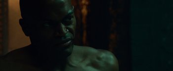 Movie still from “Dead Man Down” (2013), directed by Niels Arden Oplev – A person's face in a dark room; Close Up shot, Over the shoulder angle