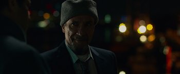 Movie still from “Dead Man Down” (2013), directed by Niels Arden Oplev – A person wearing a suit and a hat; Close Up shot, Low angle