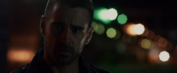 Movie still from “Dead Man Down” (2013), directed by Niels Arden Oplev – A person with a blurry background; Close Up shot, Over the shoulder angle