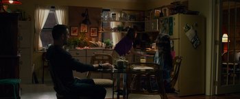 Movie still from “Dead Man Down” (2013), directed by Niels Arden Oplev – A group of people sitting around a table in a room; Wide shot, Over the shoulder angle