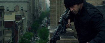 Movie still from “Dead Man Down” (2013), directed by Niels Arden Oplev – A man with a rifle looking down at a building; Medium shot, High angle
