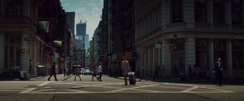 Movie still from “Dead Man Down” (2013), directed by Niels Arden Oplev – A woman is crossing the street with a suitcase; Extreme Wide shot, Low angle