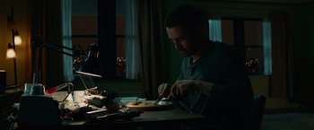 Movie still from “Dead Man Down” (2013), directed by Niels Arden Oplev – A man cutting a piece of wood on a table; Medium shot, Low angle