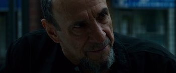 Movie still from “Dead Man Down” (2013), directed by Niels Arden Oplev – An old man with a beard and a goatee looking to his left; Close Up shot, Over the shoulder angle