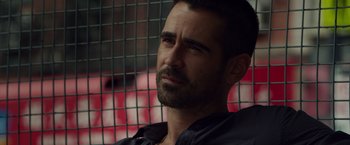 Movie still from “Dead Man Down” (2013), directed by Niels Arden Oplev – A person wearing a black shirt near a fence; Close Up shot, Over the shoulder angle