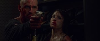 Movie still from “Dead Man Down” (2013), directed by Niels Arden Oplev – A man and a woman holding guns in a room; Close Up shot, Low angle