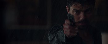 Movie still from “Dead Man Down” (2013), directed by Niels Arden Oplev – A person holding a gun in the rain; Close Up shot, Low angle