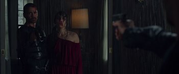 Movie still from “Dead Man Down” (2013), directed by Niels Arden Oplev – A woman in a red dress holding a gun in front of a man; Medium shot, Over the shoulder angle