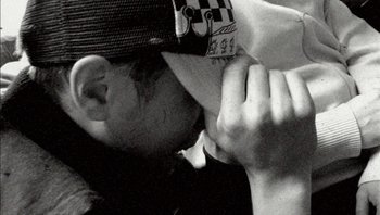 Movie still from “Dead Man's Shoes” (2004), directed by Shane Meadows – A man with a hat on his head is holding his hands to his face; Extreme Close Up shot, High angle