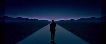 Movie still from “Dead Presidents” (1995), directed by Albert Hughes – A man in a hat is walking on a path; Extreme Wide shot, High angle