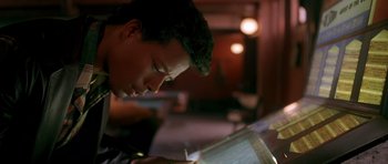 Movie still from “Dead Presidents” (1995), directed by Albert Hughes – A young man is looking down at papers; Close Up shot, Low angle