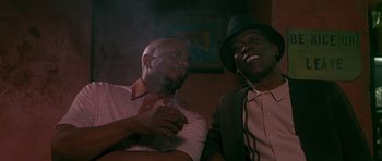 Movie still from “Dead Presidents” (1995), directed by Albert Hughes – A couple of men sitting next to each other; Close Up shot, Low angle