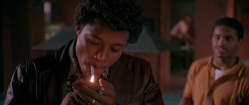 Movie still from “Dead Presidents” (1995), directed by Albert Hughes – A person holding a lit candle in their hands; Close Up shot, High angle