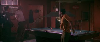 Movie still from “Dead Presidents” (1995), directed by Albert Hughes – A man standing in front of a pool table; Wide shot, Over the shoulder angle