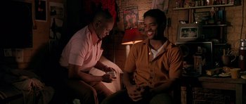 Movie still from “Dead Presidents” (1995), directed by Albert Hughes – Two men sitting in front of each other; Medium shot, High angle