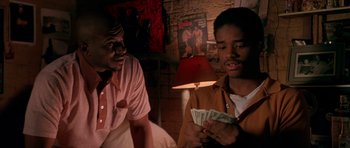 Movie still from “Dead Presidents” (1995), directed by Albert Hughes – Two men sitting next to each other holding money; Close Up shot, Over the shoulder angle