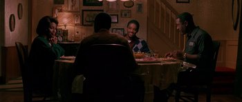 Movie still from “Dead Presidents” (1995), directed by Albert Hughes – Two men sitting at a table in a room; Medium shot, High angle