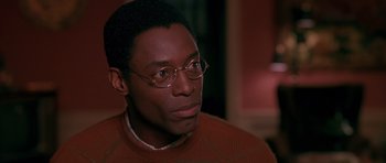 Movie still from “Dead Presidents” (1995), directed by Albert Hughes – A person wearing glasses and a sweater; Close Up shot, High angle