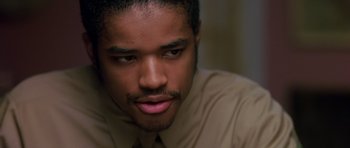 Movie still from “Dead Presidents” (1995), directed by Albert Hughes – A person wearing a dress shirt and tie; Close Up shot, Over the shoulder angle
