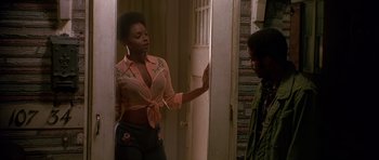 Movie still from “Dead Presidents” (1995), directed by Albert Hughes – A woman in a pink shirt is talking to a man; Medium shot, Over the shoulder angle