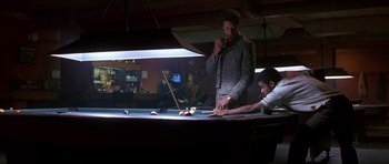 Movie still from “Dead Presidents” (1995), directed by Albert Hughes – A man standing in front of a pool table; Medium shot, Low angle