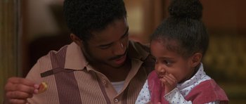 Movie still from “Dead Presidents” (1995), directed by Albert Hughes – A man and a little girl looking at each other; Close Up shot, Over the shoulder angle
