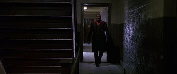 Movie still from “Dead Presidents” (1995), directed by Albert Hughes – A man walking down the hall way of a building; Wide shot, Low angle