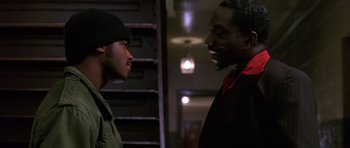 Movie still from “Dead Presidents” (1995), directed by Albert Hughes – Two men talking to each other in a dark room; Close Up shot, Over the shoulder angle