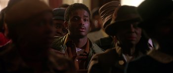 Movie still from “Dead Presidents” (1995), directed by Albert Hughes – A group of men standing around each other in a room; Close Up shot, Over the shoulder angle