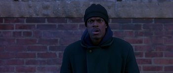 Movie still from “Dead Presidents” (1995), directed by Albert Hughes – A man in a black coat and a black hat; Close Up shot, High angle