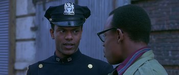 Movie still from “Dead Presidents” (1995), directed by Albert Hughes – Two police officers talking to each other; Close Up shot, Over the shoulder angle