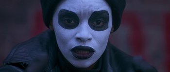 Movie still from “Dead Presidents” (1995), directed by Albert Hughes – A person with a clown makeup on their face; Close Up shot, Over the shoulder angle