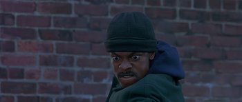 Movie still from “Dead Presidents” (1995), directed by Albert Hughes – A man in a green jacket and a black hat; Close Up shot, Low angle