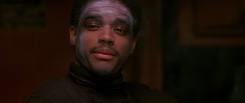 Movie still from “Dead Presidents” (1995), directed by Albert Hughes – A person wearing a black shirt; Close Up shot, Over the shoulder angle