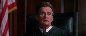 Movie still from “Dead Presidents” (1995), directed by Albert Hughes – An older man in a black robe is sitting in a chair; Close Up shot, Low angle