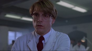 Movie still from “Dead Ringers” (1988), directed by David Cronenberg – A man in a white lab coat and a red tie; Close Up shot, Low angle