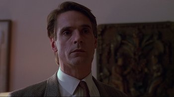 Movie still from “Dead Ringers” (1988), directed by David Cronenberg – A person wearing a suit and tie; Close Up shot, Low angle