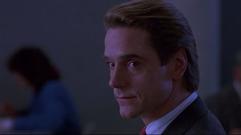 Movie still from “Dead Ringers” (1988), directed by David Cronenberg – A person wearing a suit and red tie; Close Up shot, Low angle