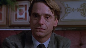 Movie still from “Dead Ringers” (1988), directed by David Cronenberg – A person wearing a suit and tie; Close Up shot, Over the shoulder angle