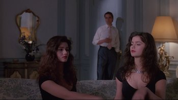 Movie still from “Dead Ringers” (1988), directed by David Cronenberg – Two women and a man are sitting in a living room; Medium shot, Low angle