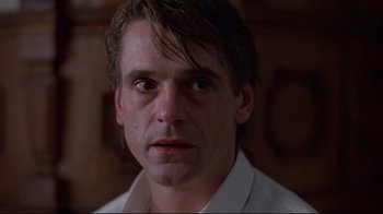 Movie still from “Dead Ringers” (1988), directed by David Cronenberg – A person wearing a white shirt; Close Up shot, Low angle
