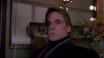 Movie still from “Dead Ringers” (1988), directed by David Cronenberg – A person wearing a suit and tie; Close Up shot, Over the shoulder angle