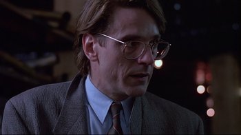 Movie still from “Dead Ringers” (1988), directed by David Cronenberg – A person wearing glasses and a suit; Close Up shot, Low angle