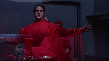 Movie still from “Dead Ringers” (1988), directed by David Cronenberg – A man in a red robe is sitting in front of a mirror; Medium shot, Low angle