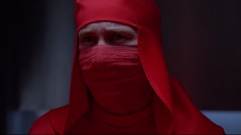 Movie still from “Dead Ringers” (1988), directed by David Cronenberg – A man in a red outfit and a red hat; Close Up shot, Low angle